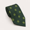 A rolled George Neale green polka dot silk tie.