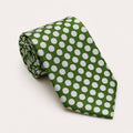 A rolled George Neale dark green and white polka dot silk tie.