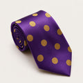 A rolled George Neale purple and gold polka dot silk tie.