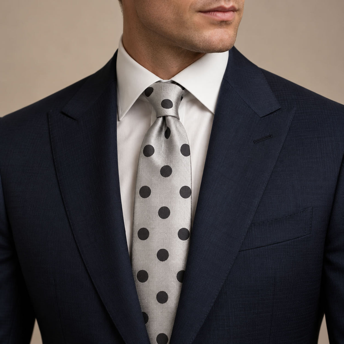 Silver Polka Dot Silk Tie by George Neale, worn by a model with a suit and shirt
