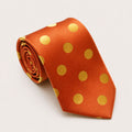 A rolled George Neale orange and gold polka dot silk tie.