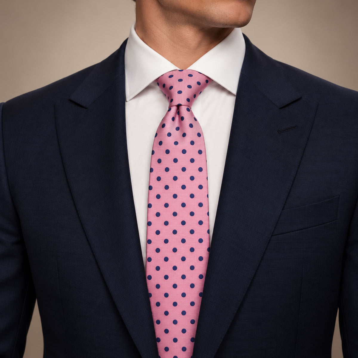 Pink and Navy Polka Dot Silk Tie by George Neale, worn by a model with a suit and shirt