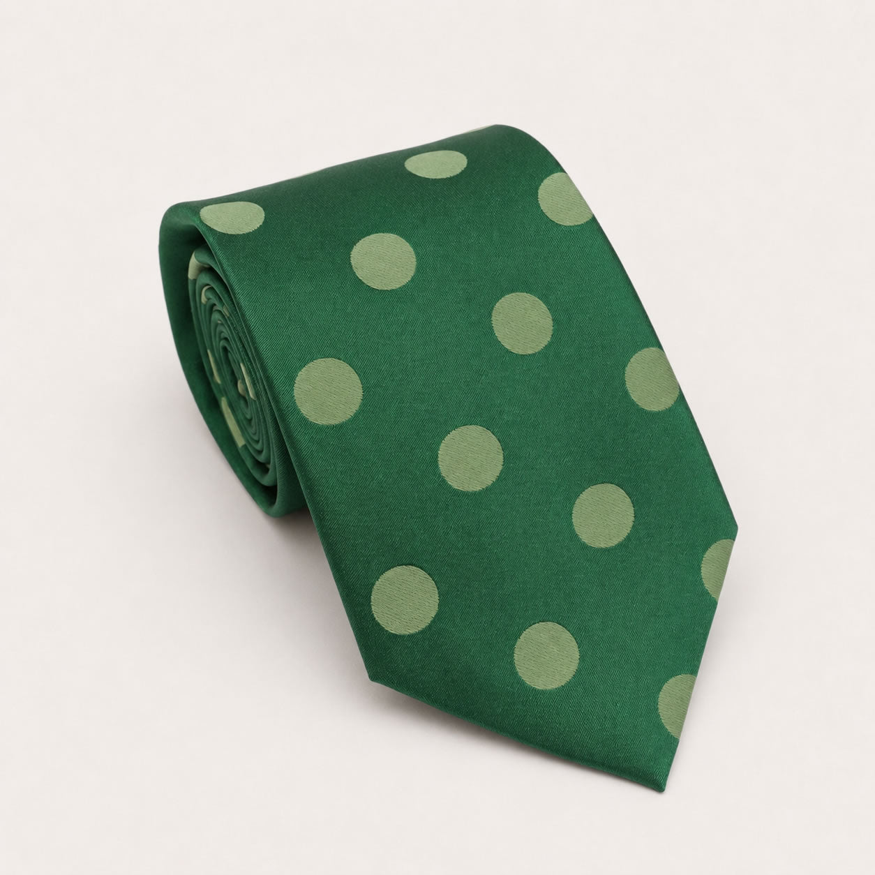 A rolled George Neale forest green polka dot silk tie.
