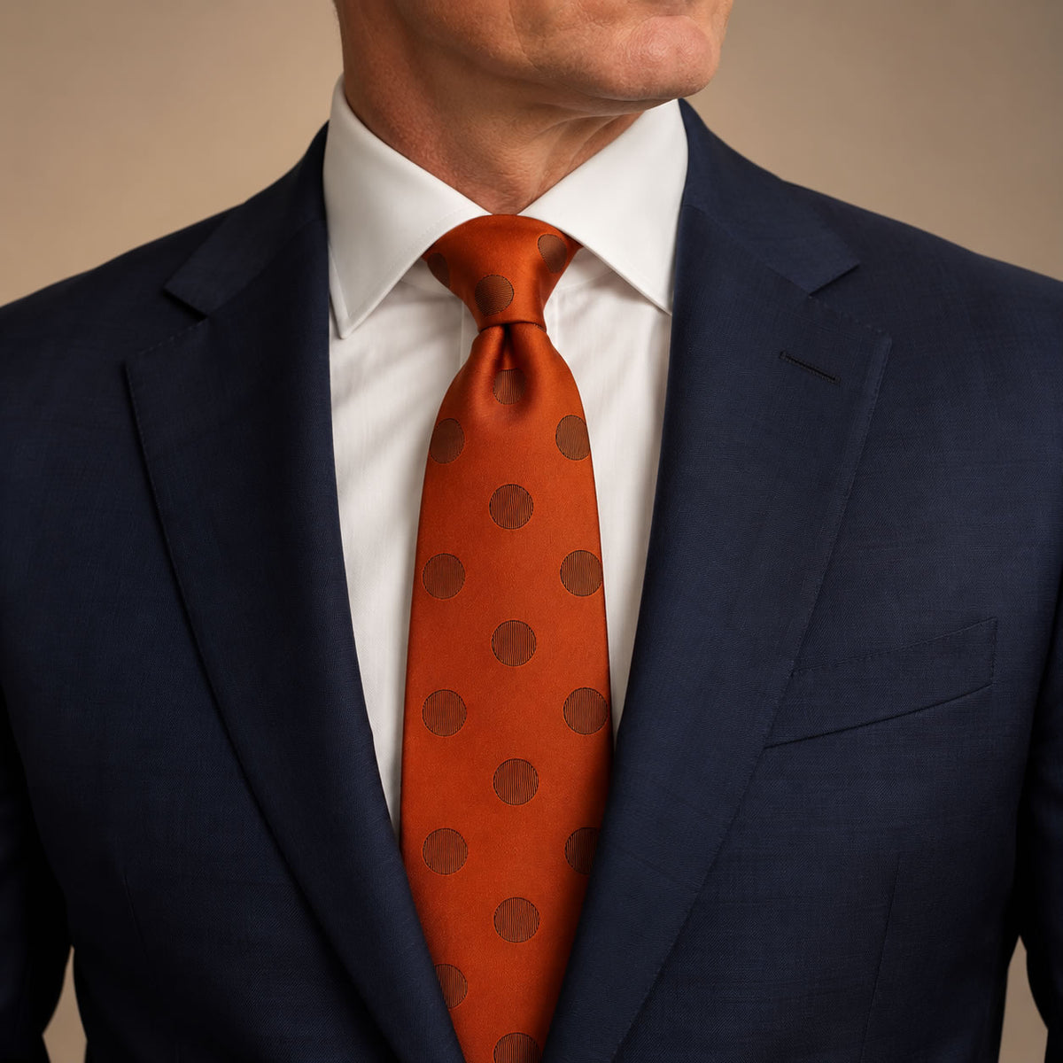 Burnt Orange Polka Dot Silk Tie by George Neale, worn by a model with a suit and shirt