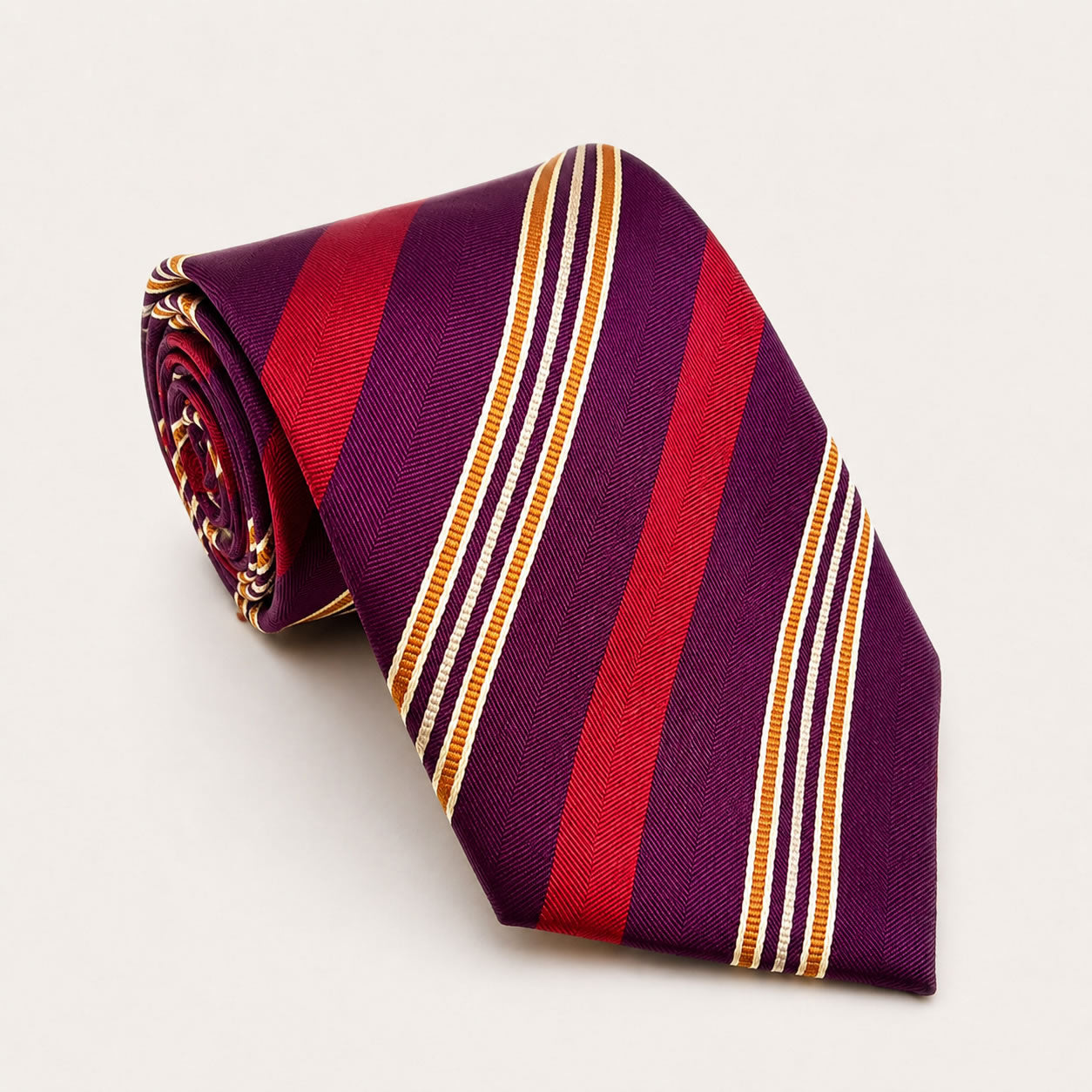 A rolled George Neale purple and maroon stripe silk tie.